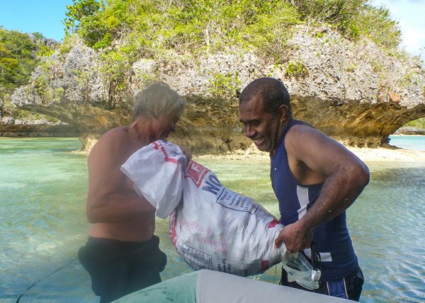 Monty and George lifting the bag of clams into the dinghy